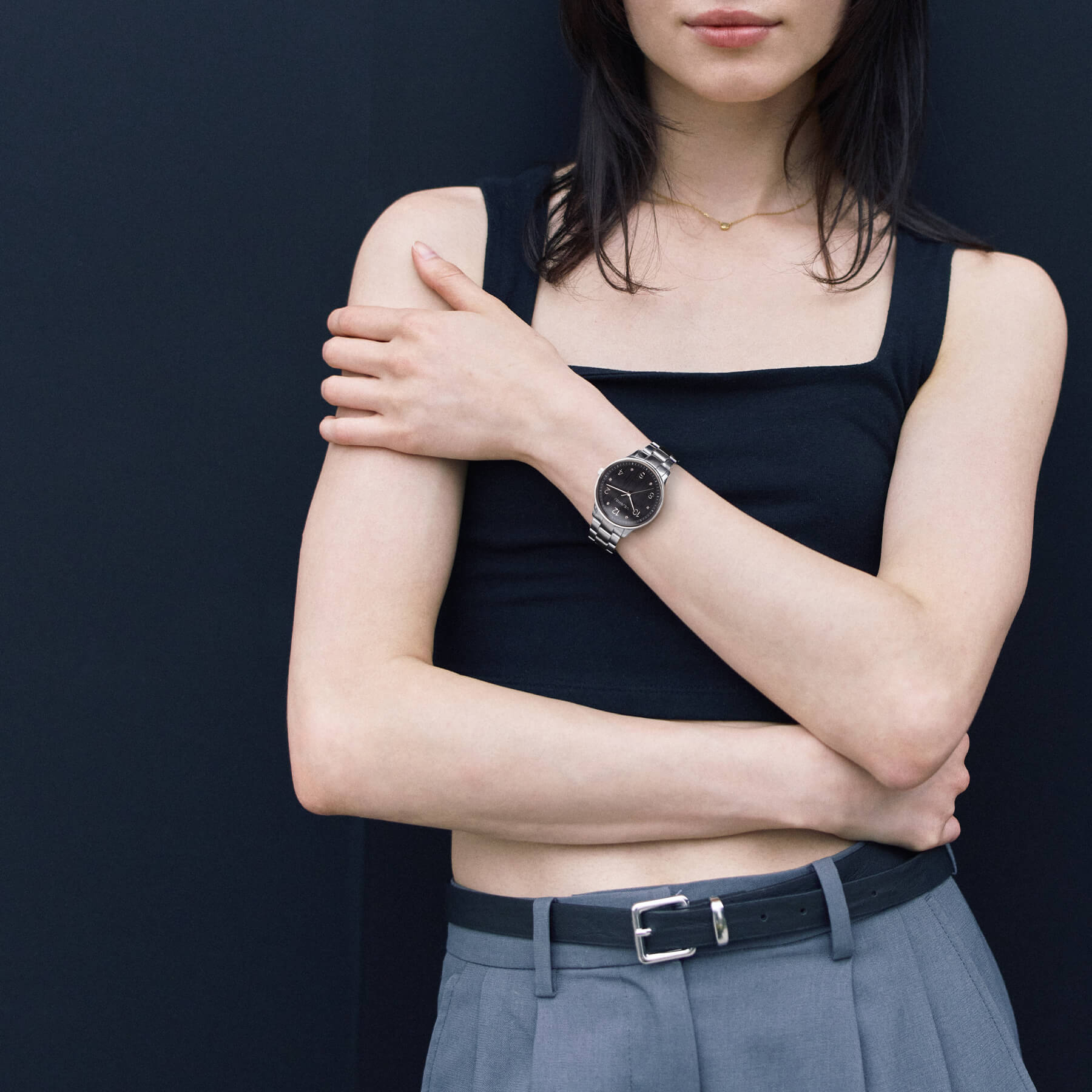 VEJRHØJのPetite Royal Black、ブラックトップスとグレーパンツのコーディネートにマッチしたシンプルで洗練された北欧デザインウォッチ