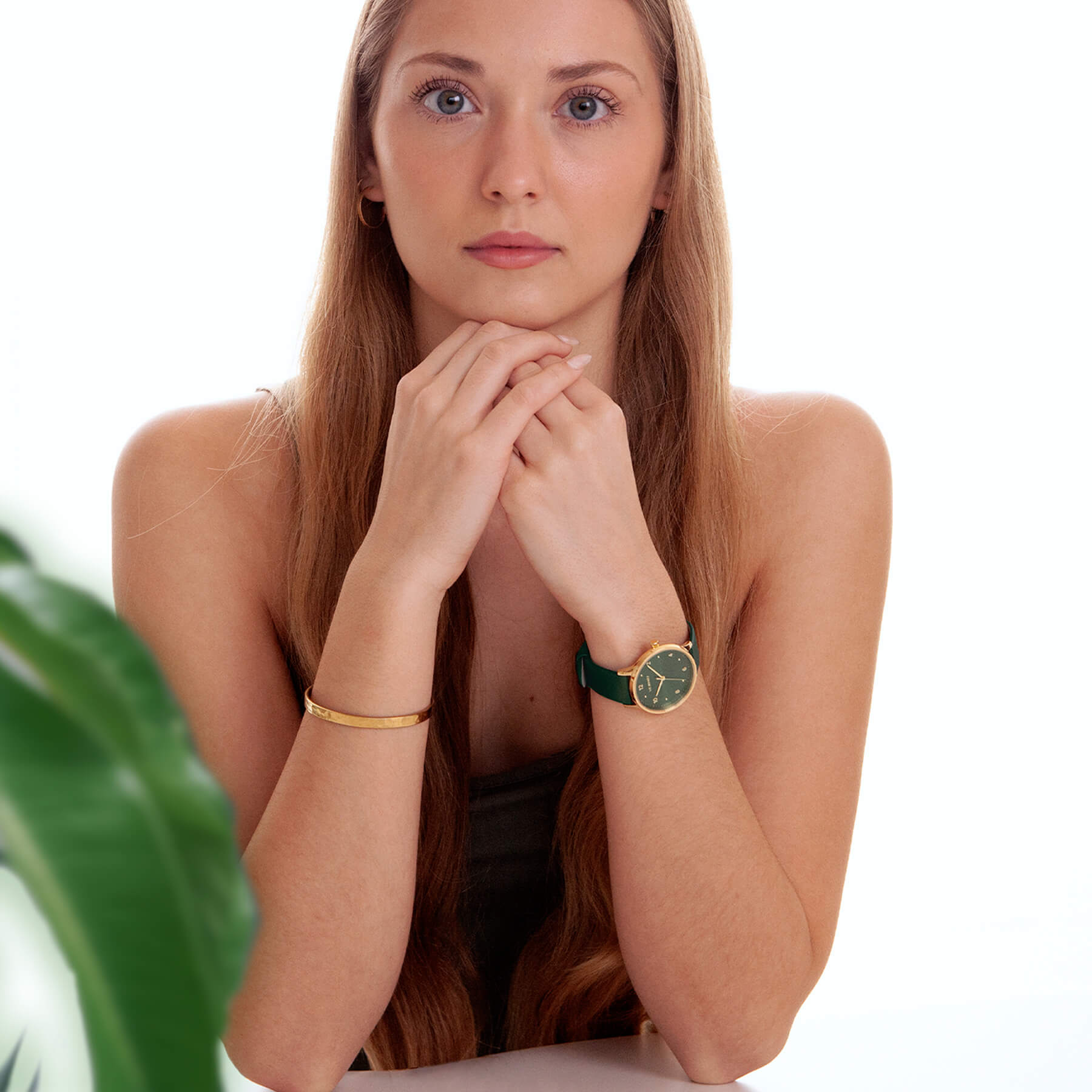 VEJRHØJの腕時計「Petite Royal Green」を着用する女性モデル。シンプルな装いに映えるグリーン×ゴールドの北欧デザイン。