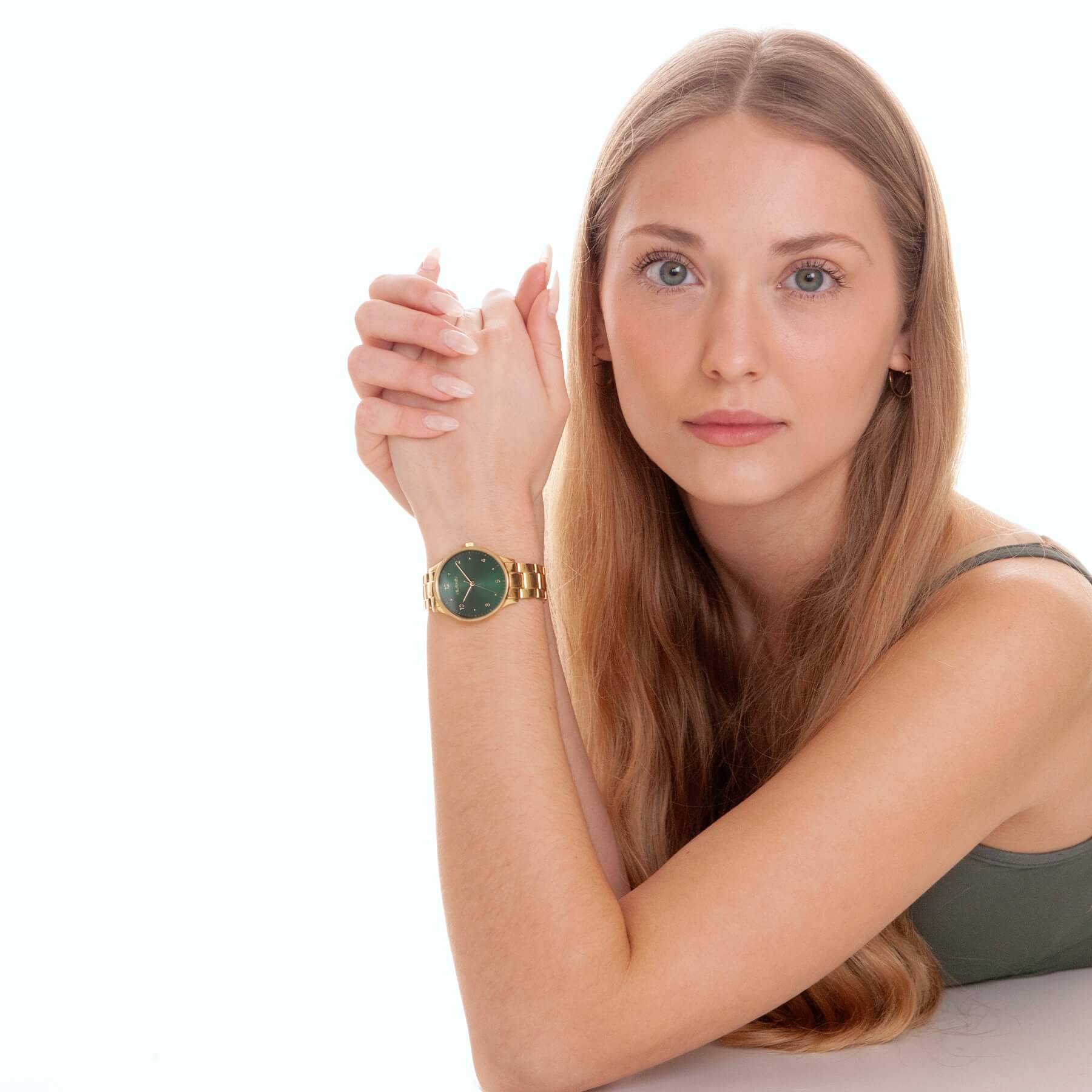 VEJRHØJ Petite Royal Greenを着用した女性、ゴールドブレスレットと深緑の円形仕上げダイヤルが映えるレディースウォッチ