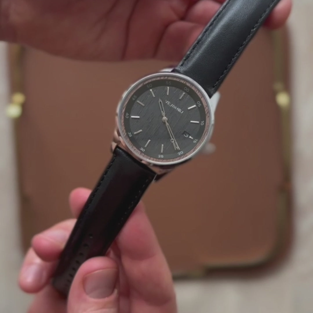 黒とシルバーを融合した機械式腕時計が見せられている