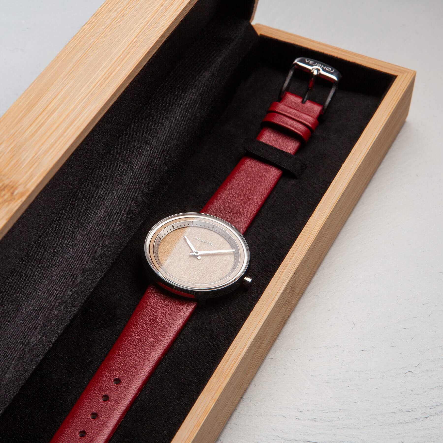 赤い色のベルトの時計が木箱に中に。ウェアホイ腕時計